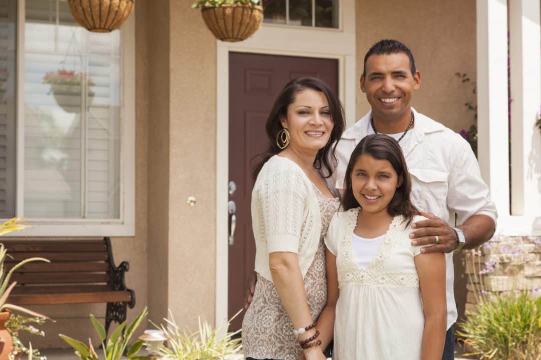 Hispanic family in front of new home Hispanic family in front of new home