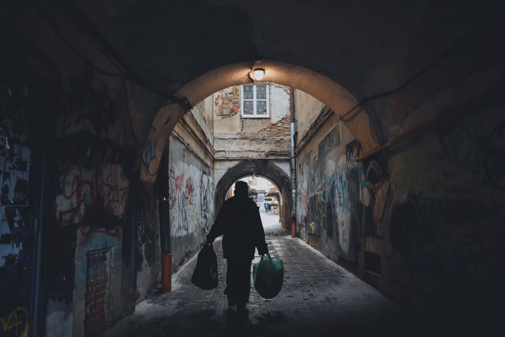 Person Carrying Bag in an Alley