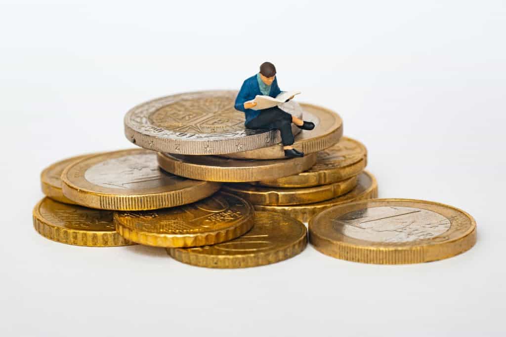 Person Sitting on Coins Reading