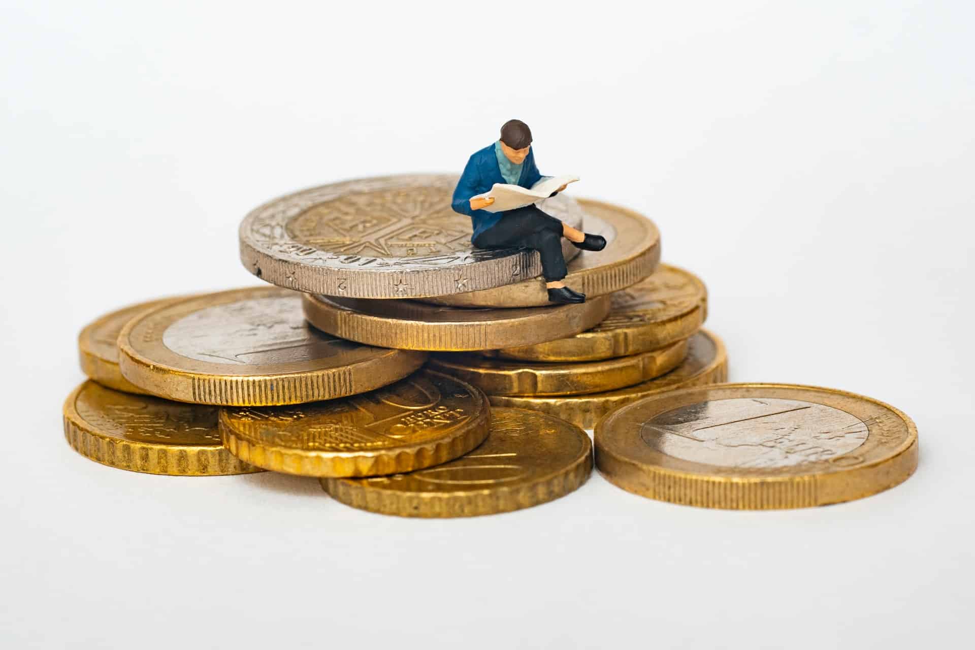 Person Sitting on Coins Reading Person Sitting on Coins Reading