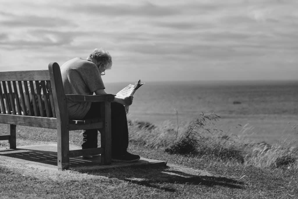 old person reading bench