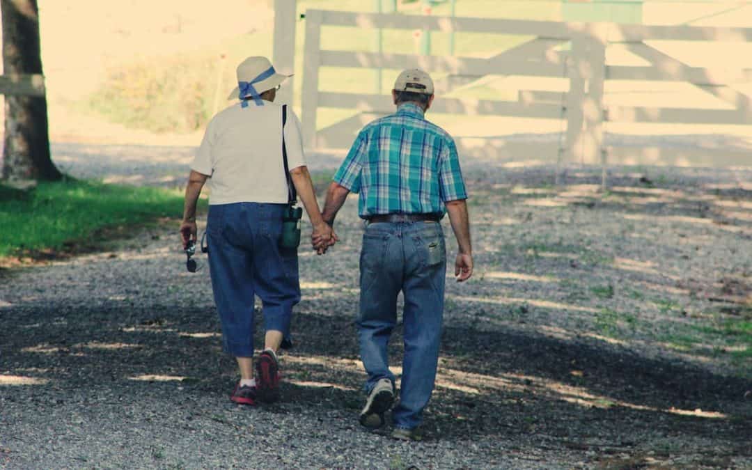 Senior couple holding hands walking