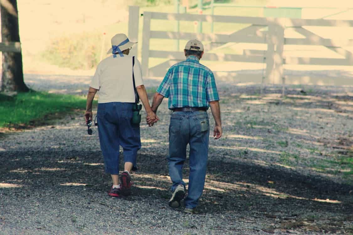 Senior couple holding hands walking Senior couple holding hands walking
