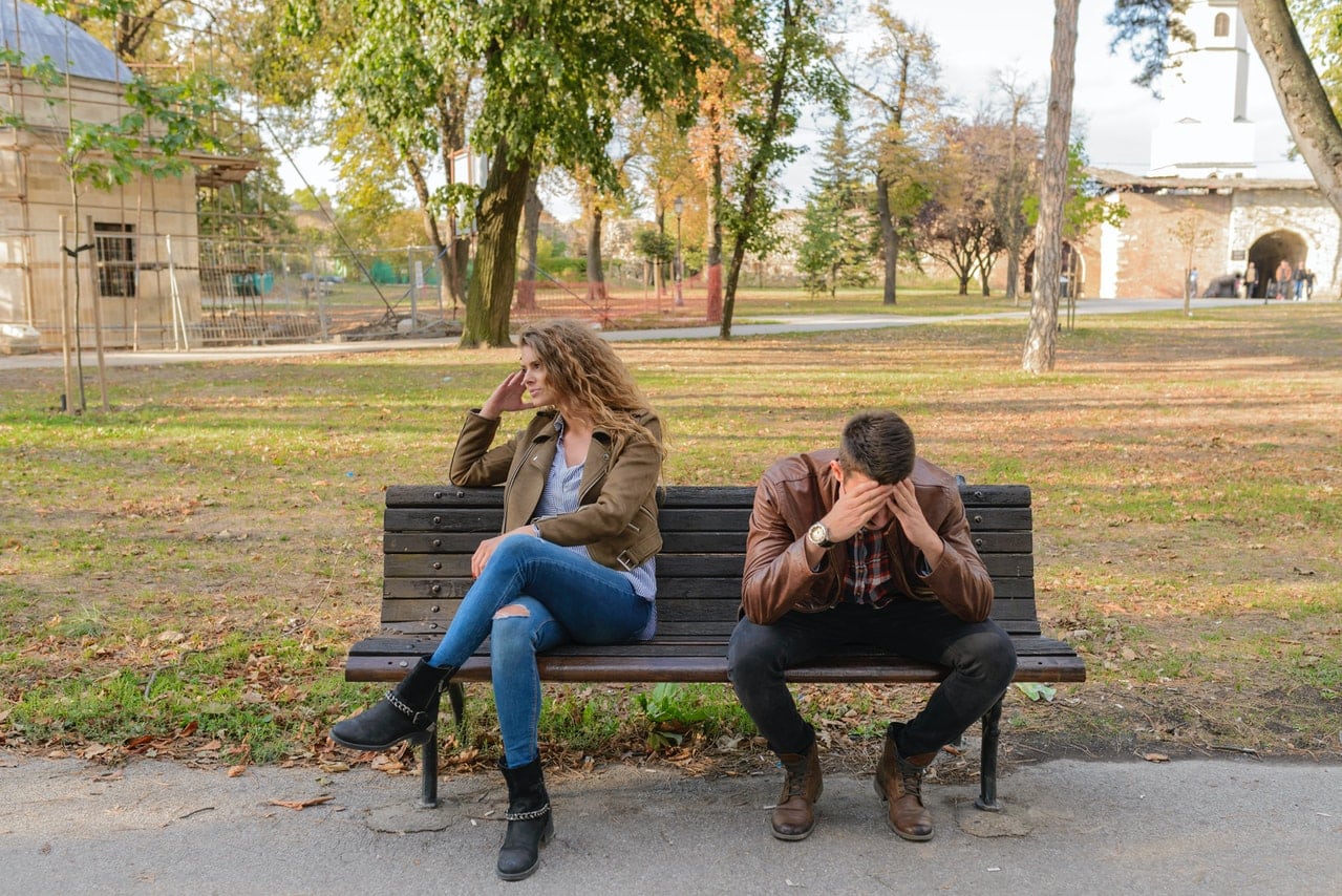 fighting couple outside on a bench