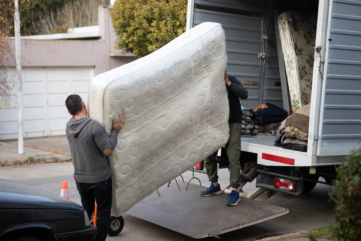 House moving process. Owner and moving staff packing, protecting and transporting furniture and movables to moving truck