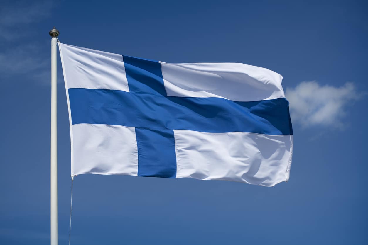 Hoisted Finnish flag with a blue sky background