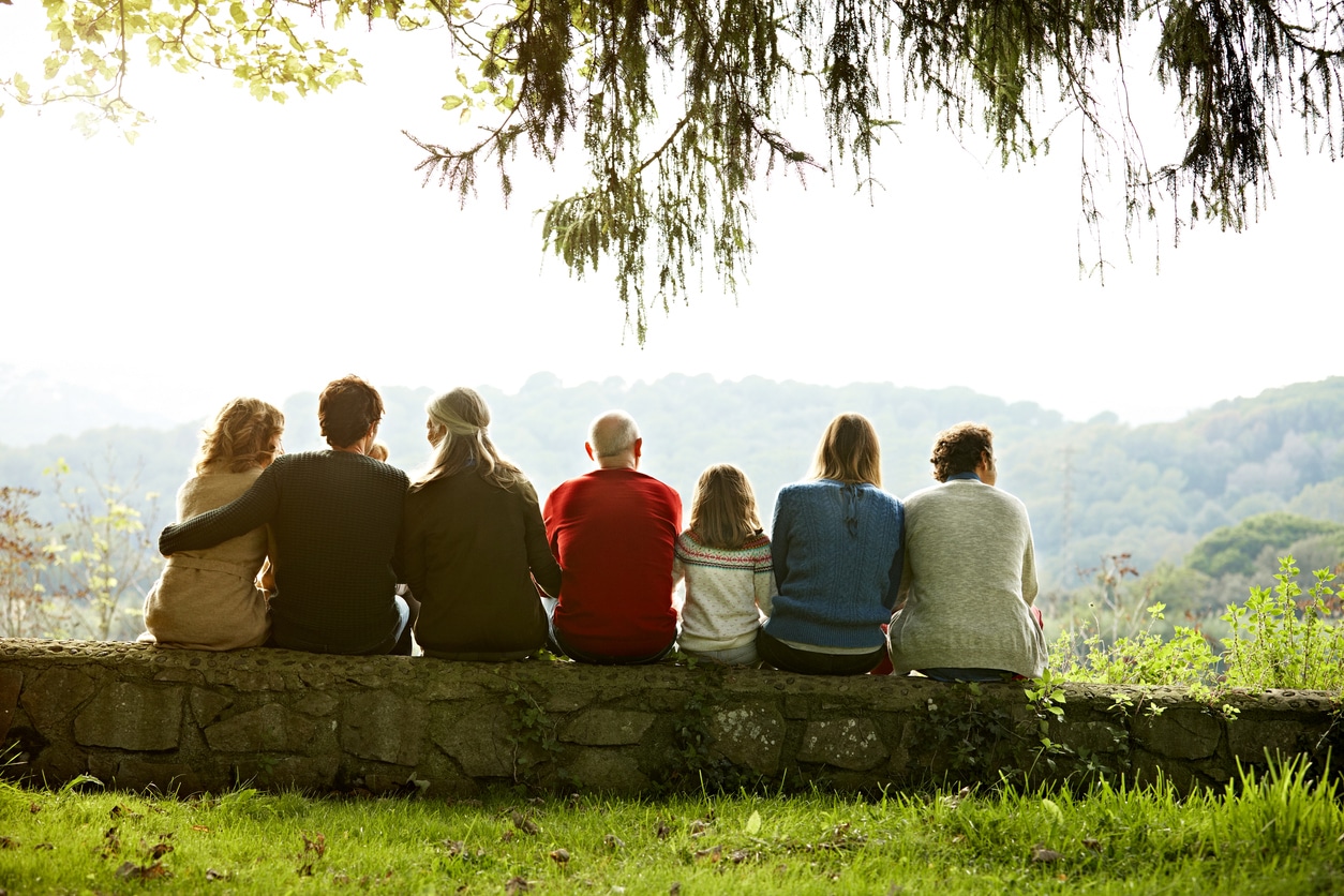 Multi-generation family relaxing on retaining wall