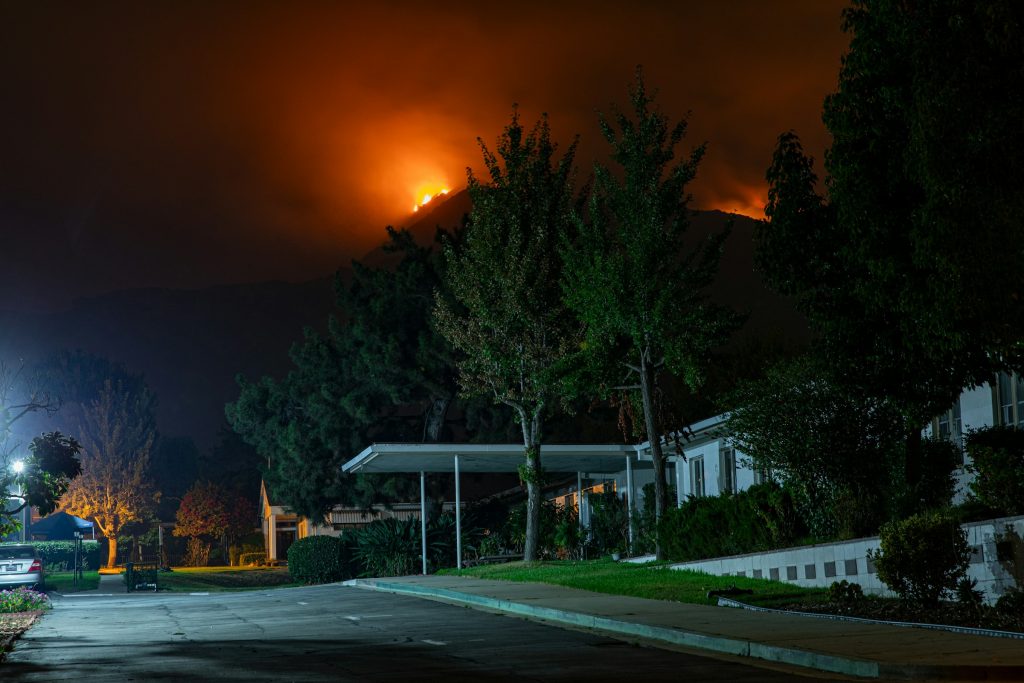Smoke from the Bobcat Fire rises behind a Southern California residential area