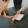 Couple signing documents at a desk, illustrating mortgage closing and digital borrower experience