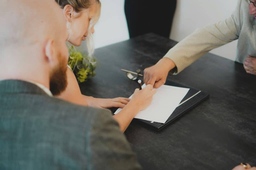 Couple signing documents at a desk, illustrating mortgage closing and digital borrower experience