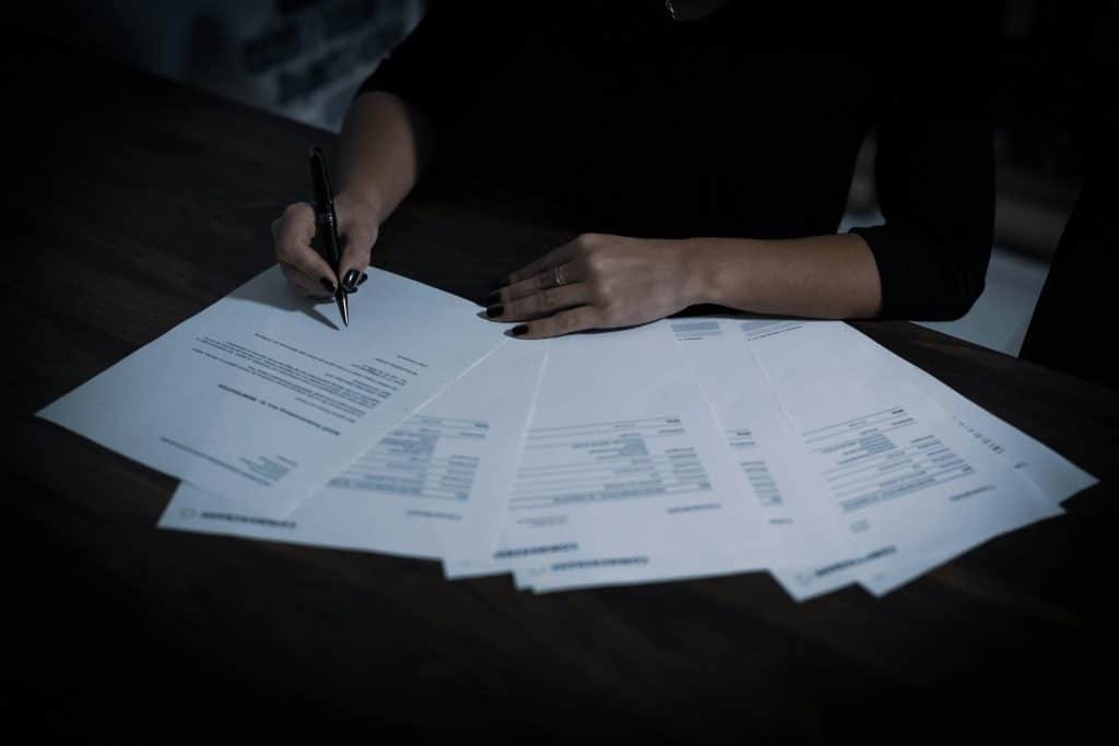 Professional signing documents, illustrating automated income and employment verification for mortgage underwriting