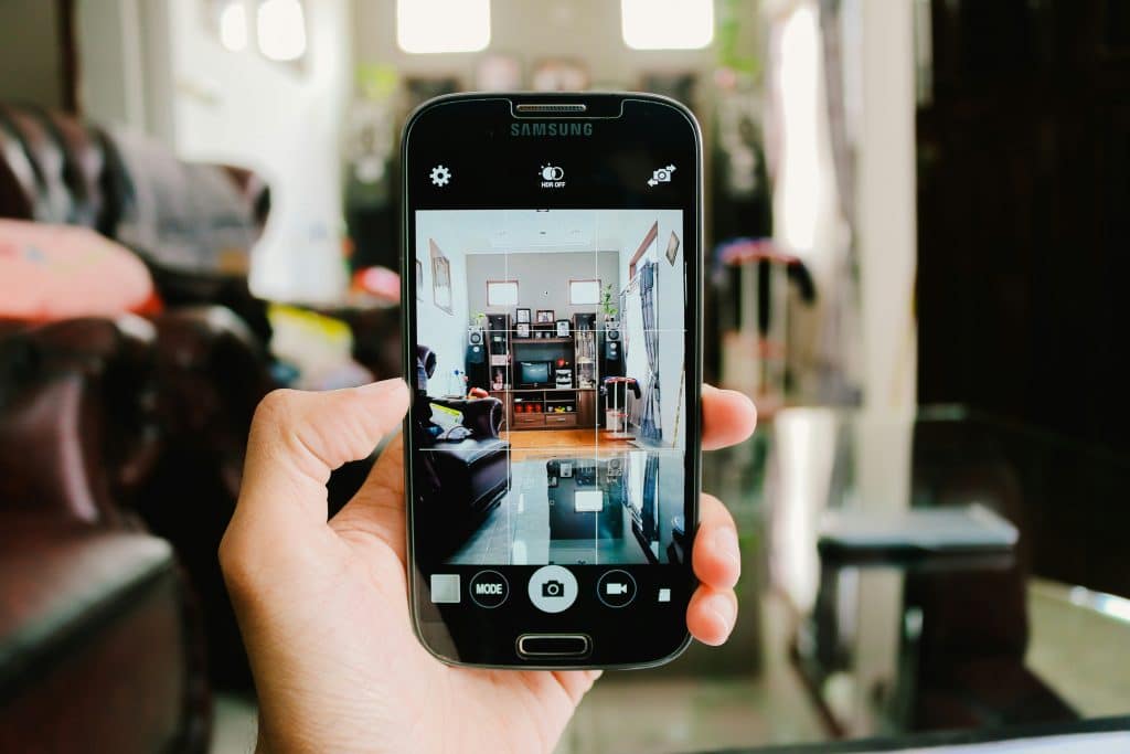 Person using a smartphone representing mobile real estate floor plan technology