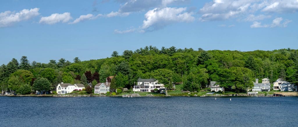 Homes along a forested lakeshore in New Hampshire, used as an illustrative image for residential development financing