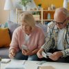 Older homeowners reviewing financial documents, illustrating housing-cost pressures