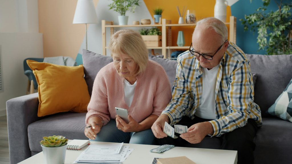Older homeowners reviewing financial documents, illustrating housing-cost pressures