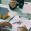 Mortgage financing documents, calculator and model home illustrating Pennymac's higher conventional loan limit