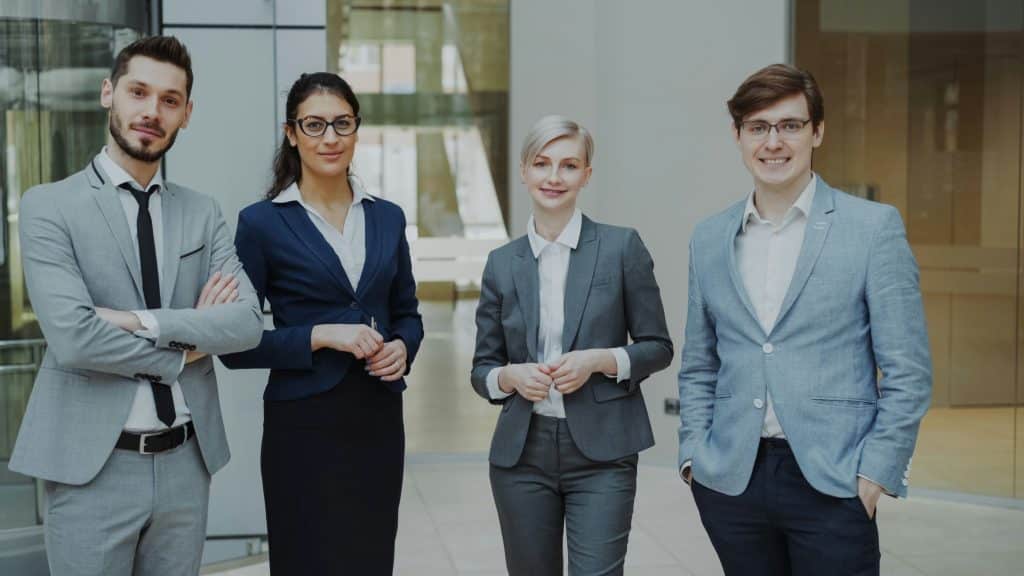 Group of real estate professionals standing together in a modern office, illustrating brokerage expansion