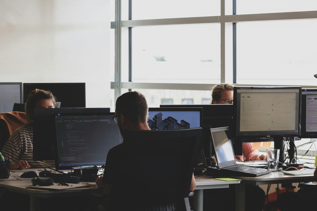 Mortgage technology professionals working at computer screens, illustrating Sagent's leadership transition and servicing technology platform