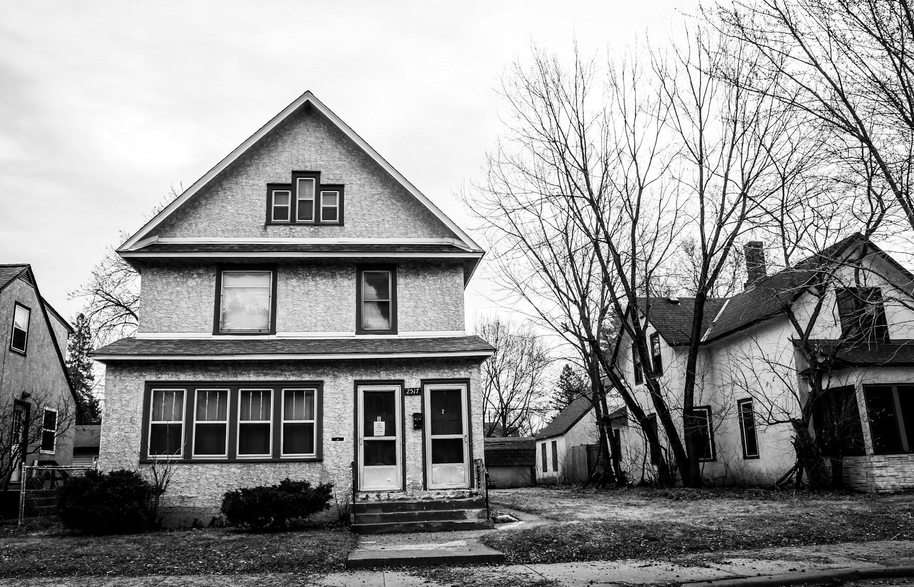 Seasoned Delinquent Mortgages — Freddie Mac NPL Sale Older detached home in a residential neighborhood, illustrating properties tied to seasoned delinquent mortgage loans.