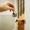Home keys being transferred at a real estate closing, illustrating title insurance activity and premium growth