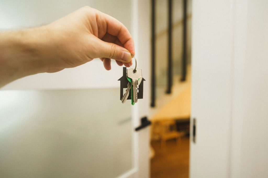 Home keys being transferred at a real estate closing, illustrating title insurance activity and premium growth