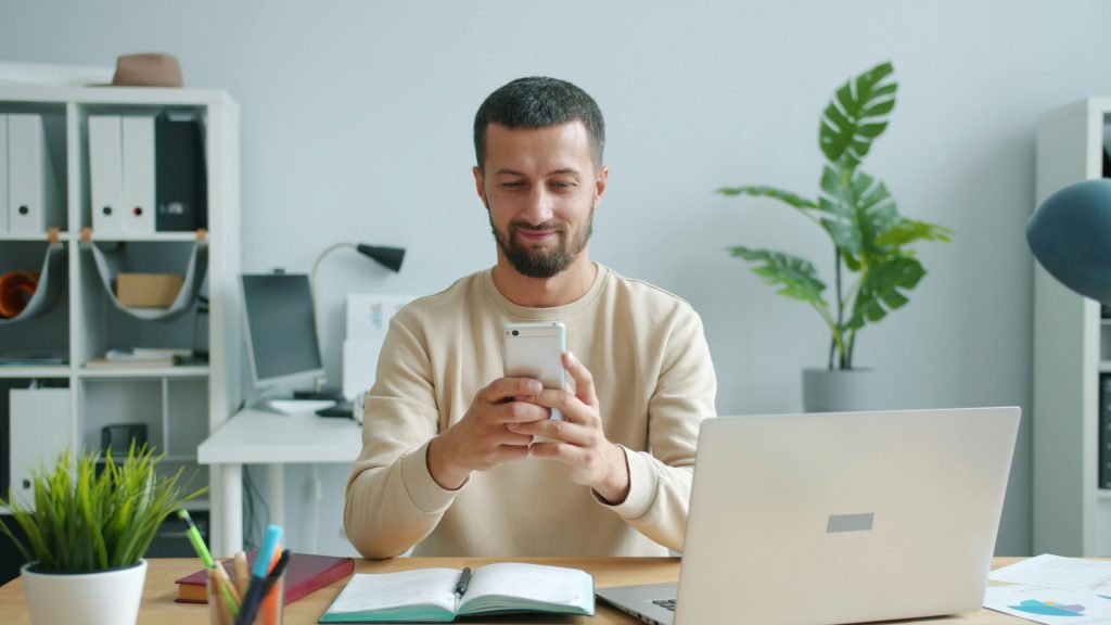 Mortgage professional using a smartphone, illustrating UWM's ChatUWM mobile app and AI voice assistant