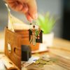 Homebuyer holding house keys with household financial paperwork, illustrating mortgage credit scoring and VantageScore 4.0