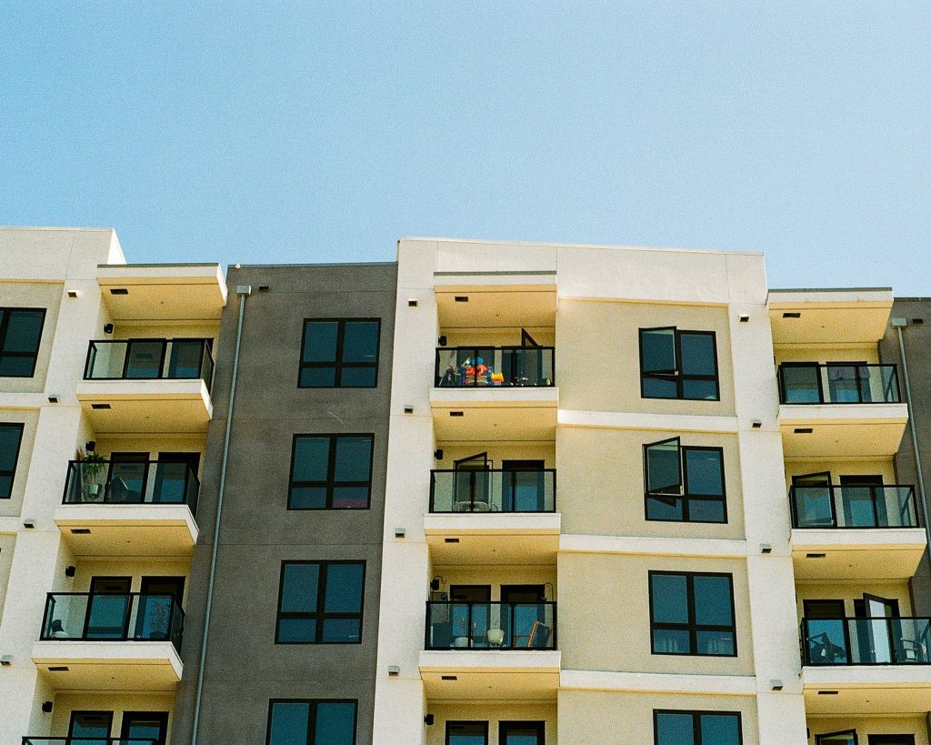 Modern apartment building with balconies against a blue sky, illustrating rental housing
