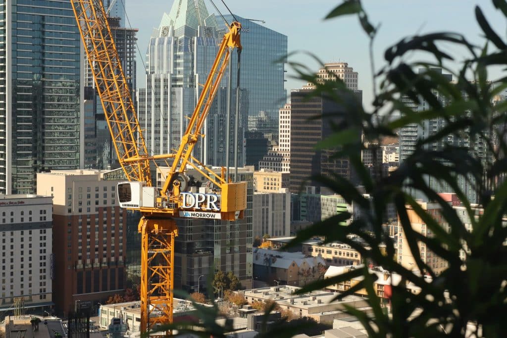 Construction crane above an urban building site, illustrating multifamily development