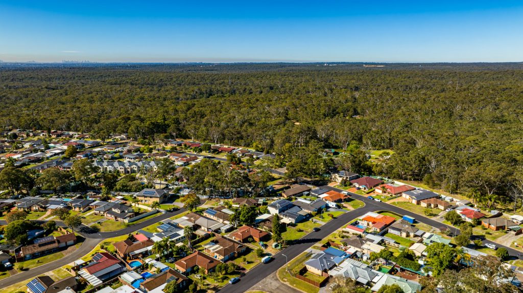 Aerial view of Australian residential housing bordering bushland, illustrating the land-lease housing market