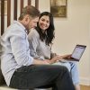 Two people reviewing a digital financial agreement on a laptop, illustrative image