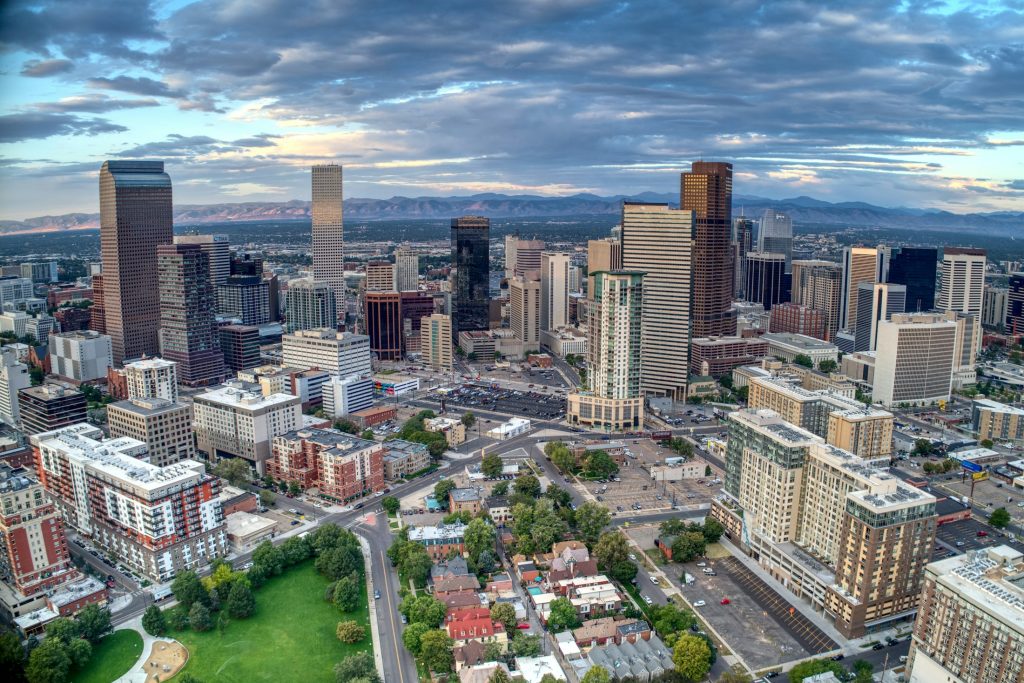 Downtown Denver skyline with Rocky Mountains, illustrating the location of a proposed Cherry Creek condominium project