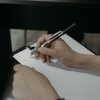 Hands writing on a clipboard illustrating FHA appraisal workflow and UAD 3.6 transition