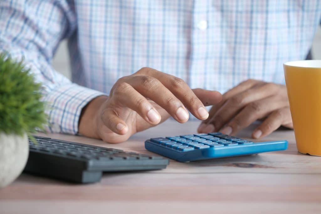 Calculator and documents illustrating mortgage servicing cost and legal reporting