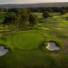 Aerial view of golf green and sand bunkers, illustrative of residential golf resort development