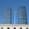 American flag between modern glass office buildings, illustrative photograph for mortgage industry transaction