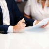 Illustrative photograph of two people discussing documents at a table; not the First Mid–Evergreen signing
