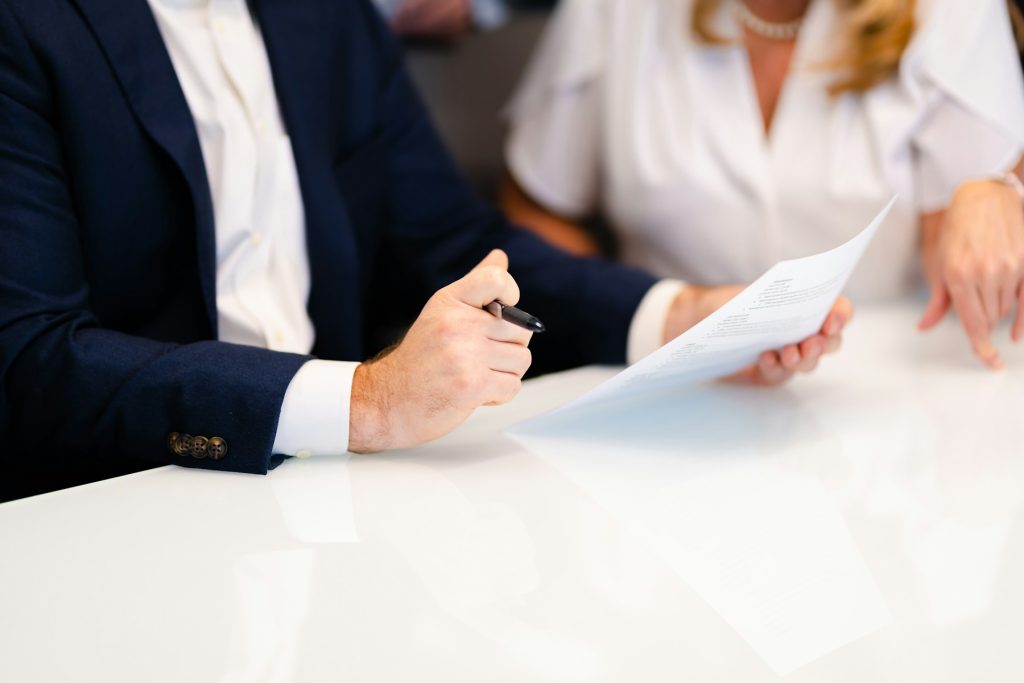 Illustrative photograph of two people discussing documents at a table; not the First Mid–Evergreen signing