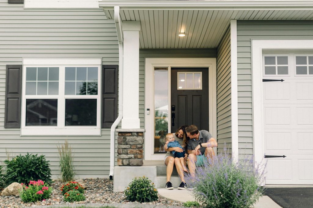 Family outside a residential home, illustrative