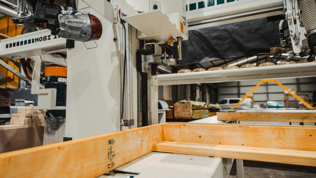 Industrial woodworking machinery processing timber inside a manufacturing facility