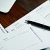 Pen resting on paperwork, illustrative image for mortgage insurance documentation