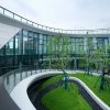 Modern multifamily apartment building with curved balconies and landscaped courtyard, illustrative image