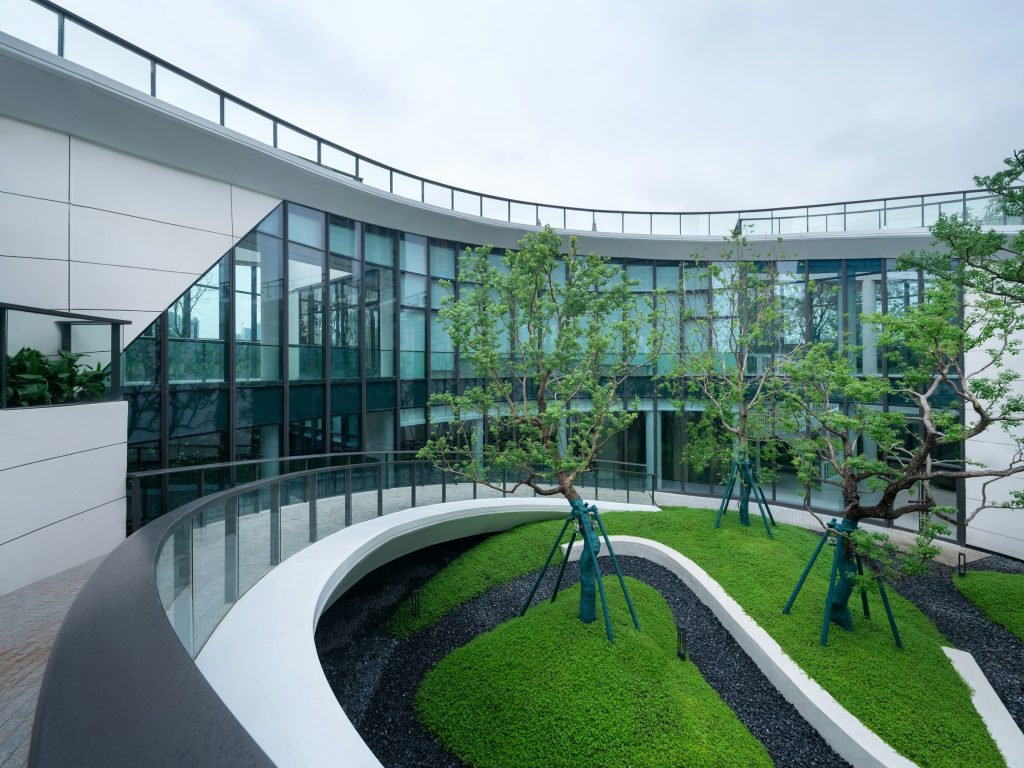 Modern multifamily apartment building with curved balconies and landscaped courtyard, illustrative image