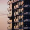 Modern multifamily apartment building with glass balconies, illustrative image for apartment financing survey