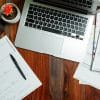 Laptop at desk illustrating credit-score processing, representative photo