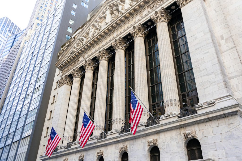 New York Stock Exchange building and American flags, where Apollo Commercial shares are expected to cease trading