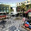 Pedestrians at an open-air shopping center, illustrating retail real estate; not Seattle University Village