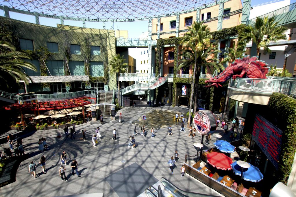 Pedestrians at an open-air shopping center, illustrating retail real estate; not Seattle University Village