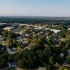 Aerial view of a residential neighborhood illustrating the debate over private listings and broad market exposure
