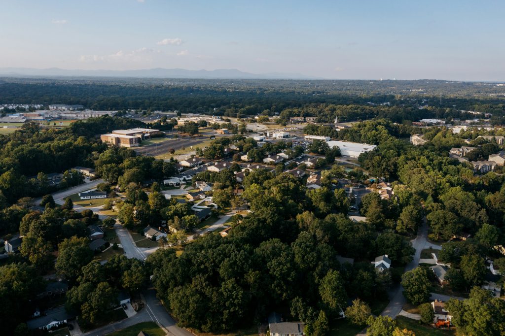 Aerial view of a residential neighborhood illustrating the debate over private listings and broad market exposure